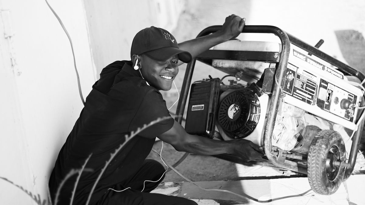 A person operating a portable backup generator outdoors